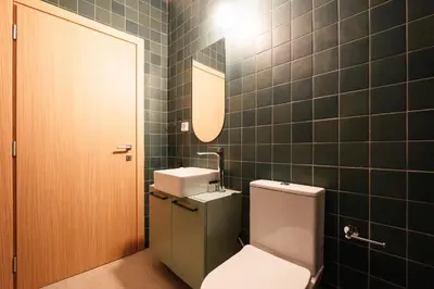 a bathroom with a toilet and a sink and a mirror at The Verve by Zoia Living in Athens