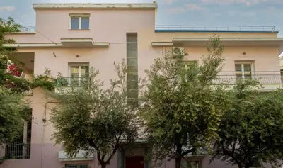 a pink building with trees in front of it at The Verve by Zoia Living in Athens