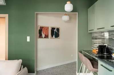 a kitchen with green walls and a white door at The Verve by Zoia Living in Athens