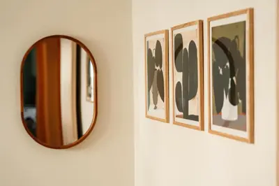 a mirror on a wall next to three framed pictures at The Verve by Zoia Living in Athens