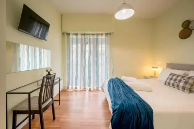 a bedroom with a bed and a desk and a television at Mia Homes - Heart of Athens in Athens