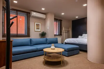 a living room with a blue couch and a bed at Lux Downtown Kolonaki in Athens