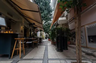 an empty street with tables and chairs in an alley at Lux Downtown Kolonaki in Athens