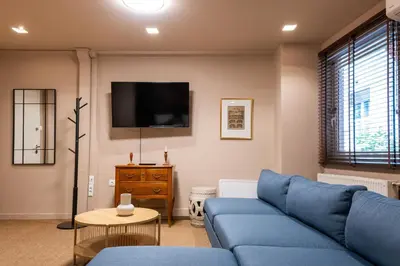 a living room with a blue couch and a tv at Lux Downtown Kolonaki in Athens