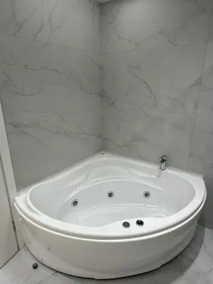 a white bath tub in a bathroom with marble walls at Belle Athenes Apartements in Athens