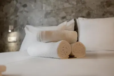 a pile of towels sitting on top of a bed at Belle Athenes Apartements in Athens