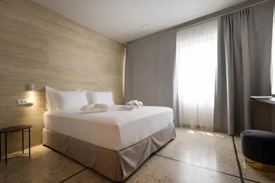 a bedroom with a large white bed and a window at Belle Athenes Apartements in Athens