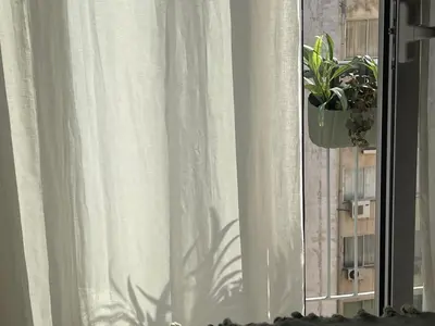 a window with a white curtain and a potted plant at Athenian Boho Nest by 8essentially in Athens