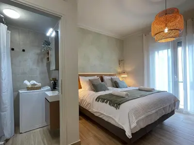 a bedroom with a large bed and a bathroom at Athenian Boho Nest by 8essentially in Athens