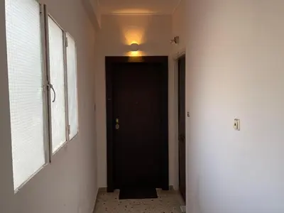 a hallway with a black door and a light on the ceiling at Athenian Boho Nest by 8essentially in Athens
