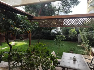 an outdoor patio with a table and an orange tree at Cleo's Garden House in Athens