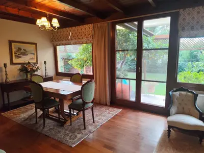 a dining room with a table and chairs and windows at Cleo's Garden House in Athens