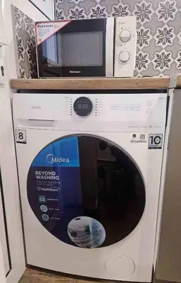 a microwave sitting on top of a washing machine at LYT house at the foot of the Acropolis in Athens