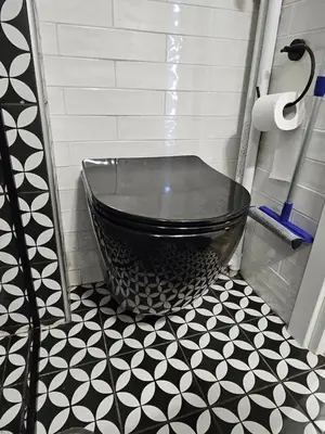 a bathroom with a black tub and a black and white floor at LYT house at the foot of the Acropolis in Athens