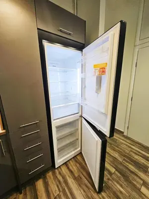 an empty refrigerator with its door open in a kitchen at LYT house at the foot of the Acropolis in Athens