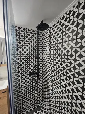 a shower with a black and white patterned wall at LYT house at the foot of the Acropolis in Athens