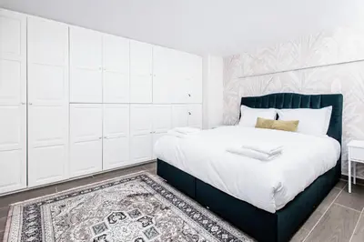 a bedroom with a bed with white cabinets and a rug at MZ Kolonaki Hills in Athens