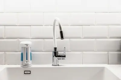 a sink with a faucet on a white tiled wall at MZ Kolonaki Hills in Athens