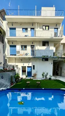 an apartment building with a swimming pool in front of it at Apartments Sunshine G1 in Athens