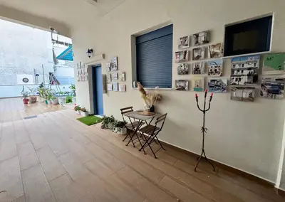 a room with a table and chairs and a wall with pictures at Apartments Sunshine G1 in Athens