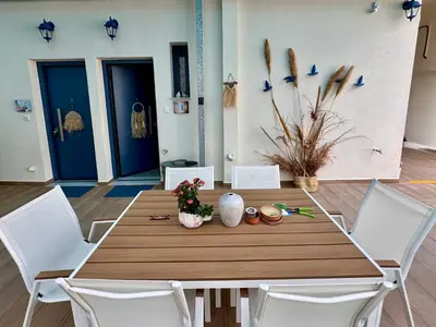 a dining room table with white chairs and blue doors at Apartments Sunshine G1 in Athens