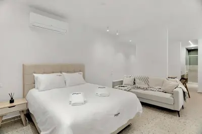 a white bedroom with a large bed and a couch at Athenian Harmony Parliament Square Athens Centre in Athens