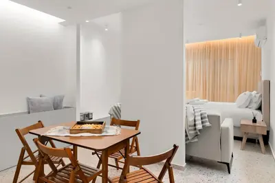 a dining room with a table and chairs and a bedroom at Athenian Harmony Parliament Square Athens Centre in Athens