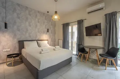 a bedroom with a bed and a table and chairs at The Suite by Spaceers in Athens