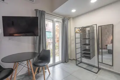 a living room with a table and chairs and a tv at The Suite by Spaceers in Athens