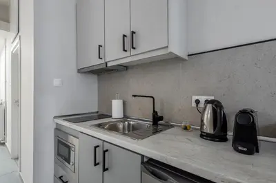 a kitchen with white cabinets and a sink at The Suite by Spaceers in Athens