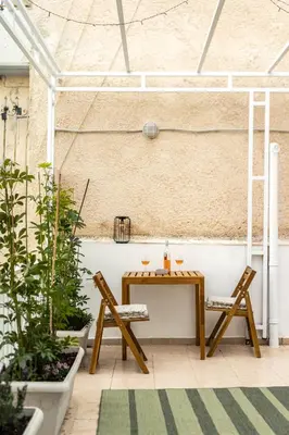 a table and two chairs in a room with plants at 2BR Family Apt for 6 and a Large Sunny Balcony in Athens