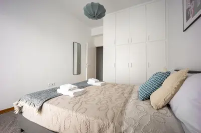 a bedroom with a large bed with white cabinets at 2BR Family Apt for 6 and a Large Sunny Balcony in Athens