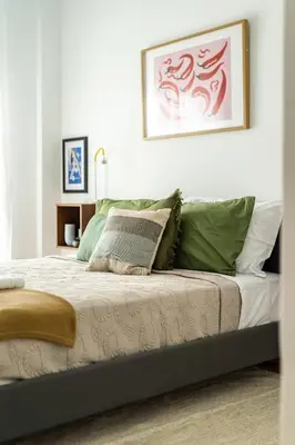 a bedroom with a bed with green and white pillows at 2BR Family Apt for 6 and a Large Sunny Balcony in Athens