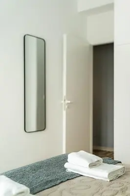 a bathroom with a mirror and towels on a bed at 2BR Family Apt for 6 and a Large Sunny Balcony in Athens