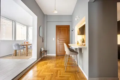 a kitchen and living room with a table and chairs at 2BR Family Apt for 6 and a Large Sunny Balcony in Athens