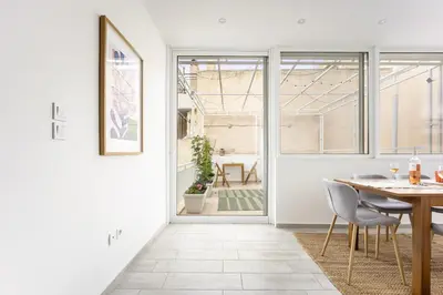 a dining room with a table and chairs and a door at 2BR Family Apt for 6 and a Large Sunny Balcony in Athens
