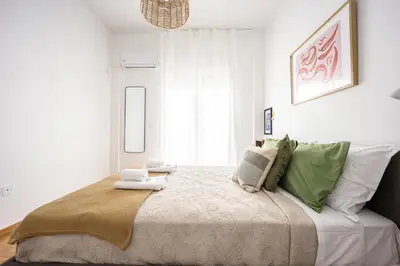a bedroom with a large bed with green and white pillows at 2BR Family Apt for 6 and a Large Sunny Balcony in Athens