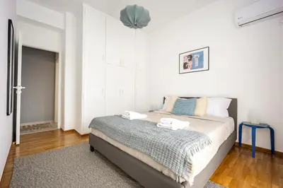 a bedroom with a bed in a white room at 2BR Family Apt for 6 and a Large Sunny Balcony in Athens