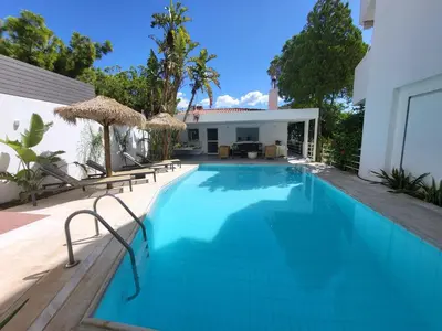 a swimming pool with chairs and a house at El Mar, Pool House with 3 BDR, 7 min from beach in Saronida