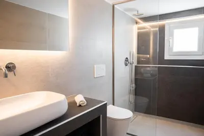 a bathroom with a sink and a toilet and a shower at El Mar, Pool House with 3 BDR, 7 min from beach in Saronida