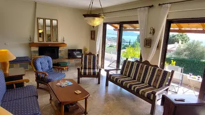 a living room with a couch and chairs and a fireplace at Summer Breeze villa in Saronic Gulf in Anavissos