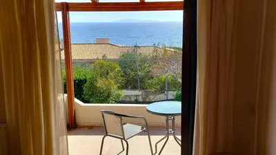 a balcony with a table and a view of the ocean at Summer Breeze villa in Saronic Gulf in Anavissos