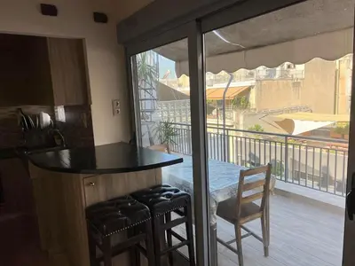 a kitchen with a bar with a view of a balcony at Penthouse Athens centre-Skythens in Athens