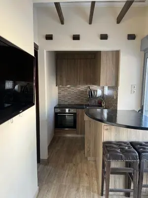 a kitchen with wooden cabinets and a black counter top at Penthouse Athens centre-Skythens in Athens