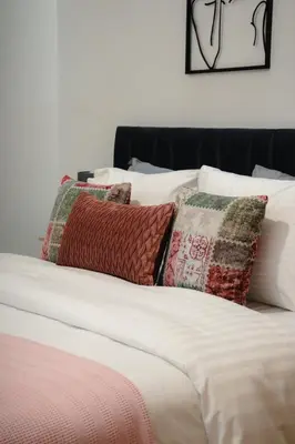 a bed with white sheets and pillows on it at Stefanos flat in the heart of Koukaki 2BD in Athens