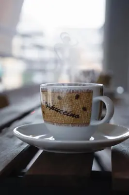 a coffee cup sitting on a plate on a table at Stefanos flat in the heart of Koukaki 2BD in Athens