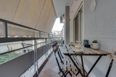 an apartment balcony with a wooden table and chairs at Stefanos flat in the heart of Koukaki 2BD in Athens