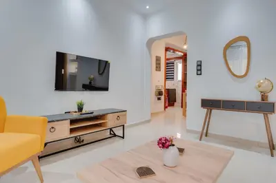 a living room with a yellow couch and a tv at Stefanos flat in the heart of Koukaki 2BD in Athens