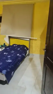 a bed in a room with a blue blanket on it at أثينا in Athens