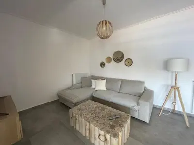 a living room with a couch and a coffee table at Beachfront Apartment in Varkiza in Vari